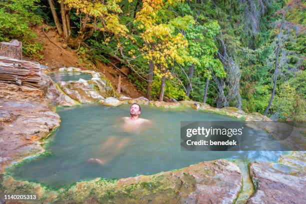 man relaxes in umpqua hot springs in oregon usa - hot spring stock pictures, royalty-free photos & images