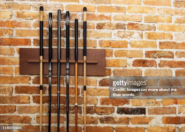 a set of snooker clubs againts a brick wall. still life. - pool cue sport stock pictures, royalty-free photos & images
