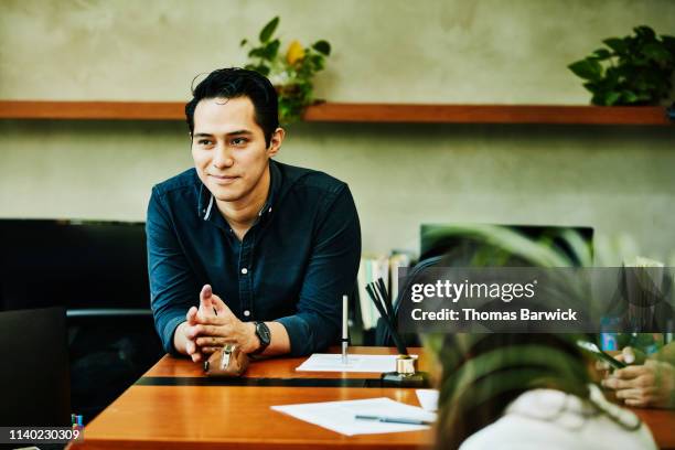 portrait of smiling male architect leaning on desk in studio - trabalho de design imagens e fotografias de stock