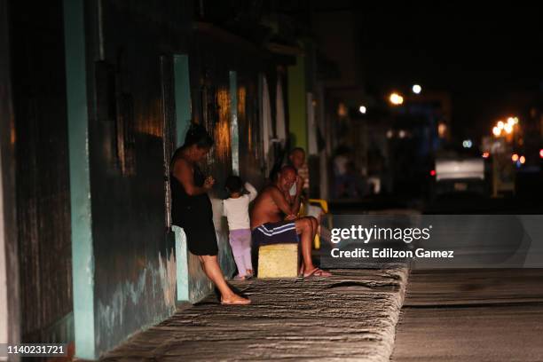 Neighbors sit in the from of their houses during a blackout on April 28, 2019 in Barquisimeto, Venezuela.