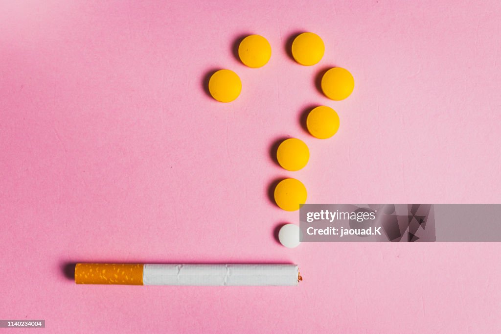 Fragezeichen aus Pillen und einer Zigarette. Arztprobleme.