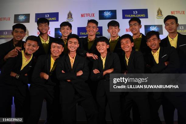 Members of the 'Wild Boars' football team pose for a photo with their coach Ekkapol Chantawong before a press conference in Bangkok on April 30, 2019...