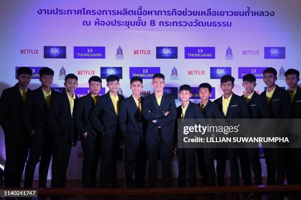 Members of the 'Wild Boars' football team pose for a photo with their coach Ekkapol Chantawong during a press conference in Bangkok on April 30, 2019...