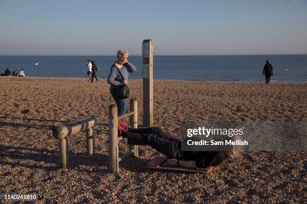 An older man using beach fitness equipment at Hastings seafront on the 20th April 2019 in Hastings in the United Kingdom. Hastings is a town on...