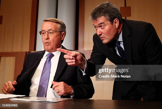 Treasurer Wayne Swan receives instructions from Maurice Reilly of the National Press Club before he delivers his fourth annual post-budget address to...