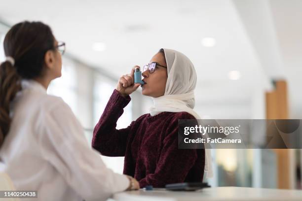 woman testing her puffer - asthma in adults stock pictures, royalty-free photos & images