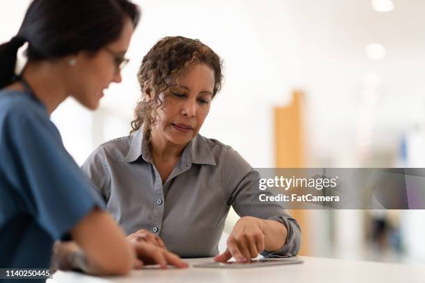 doctora mujer hablando con su paciente senior - procedimiento fotografías e imágenes de stock