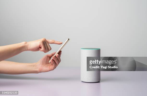 woman using a smart speaker with smart phone. - equipment stock pictures, royalty-free photos & images