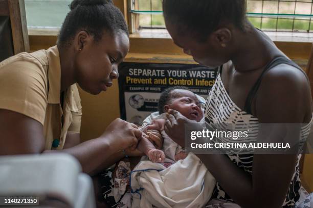 Nurse administers a vaccine to a child at Ewin Polyclinic in Cape Coast on April 30, 2019. - Ewim Polyclinic was the first in Ghana to roll out the...