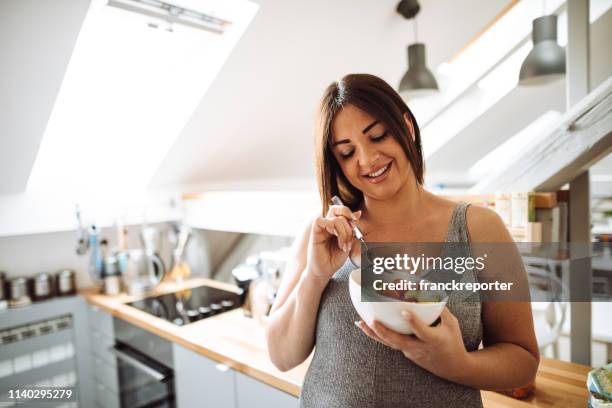 pregnant woman eating healthy food at home - women abdomen stock pictures, royalty-free photos & images