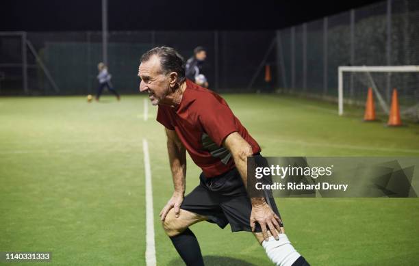 senior man warming-up before playing soccer - injured football player stock pictures, royalty-free photos & images