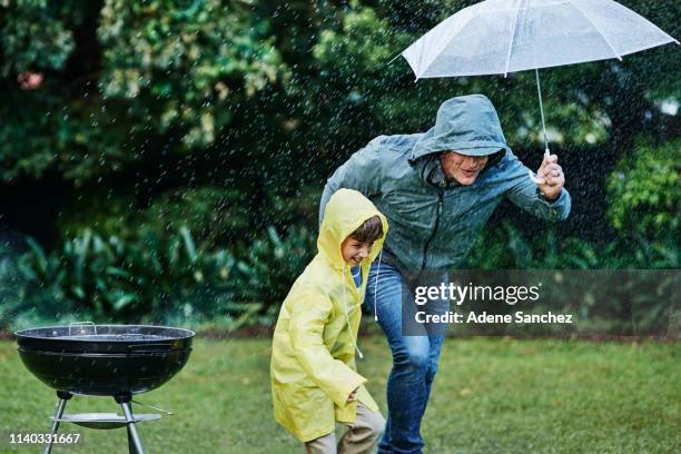 run for cover when the rain gets too much - family cover stock pictures, royalty-free photos & images