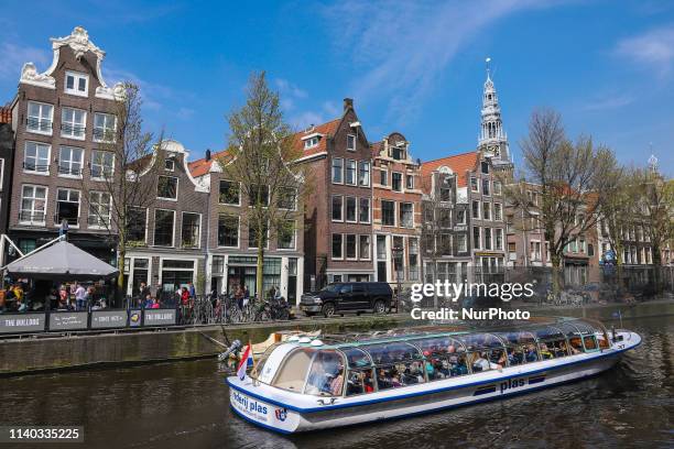 Boats and vessels inside the canals of Amsterdam in The Netherlands, with traditional houses and bridges over the water. The little ships are used...