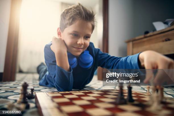 little boy having fun playing chess - kids playing chess stock pictures, royalty-free photos & images