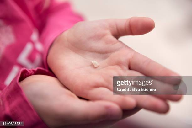 child holding lost milk tooth in hands - tooth fairy stock pictures, royalty-free photos & images