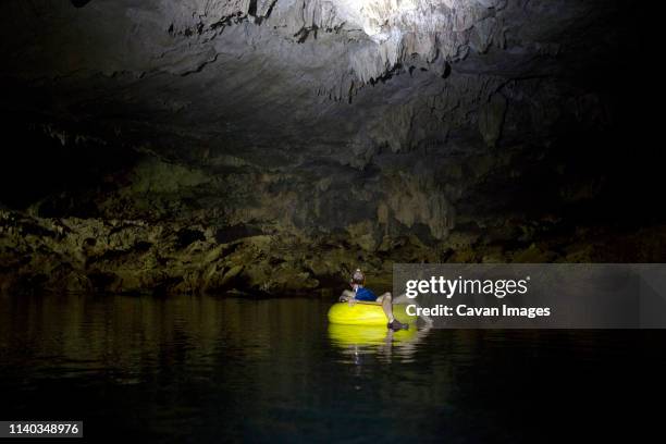 man river tubbing in a cave - cave torch stock pictures, royalty-free photos & images