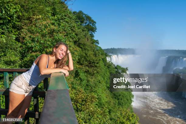 jovencita visitando las cataratas del iguazú en brasil - cataratas del iguazú fotografías e imágenes de stock