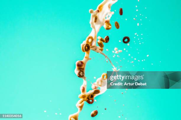 milk and fruit loops cereals splashing in the air. - falling food stock pictures, royalty-free photos & images