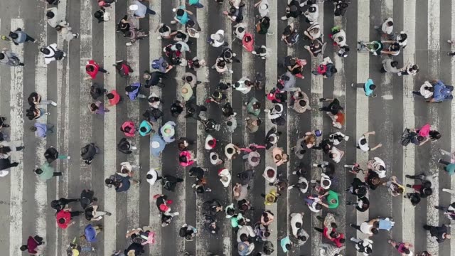Aerial view of pedestrians walking across with crowded traffic