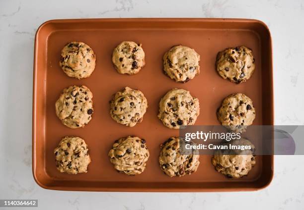 sheet pan of freshly baked chocolate chip cookies shot from above - baking tray stock pictures, royalty-free photos & images