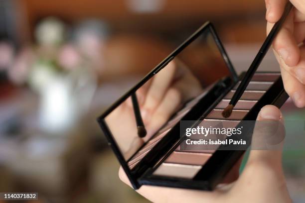 close up of woman brushing with eye shadow pallet - eye shadow stock-fotos und bilder