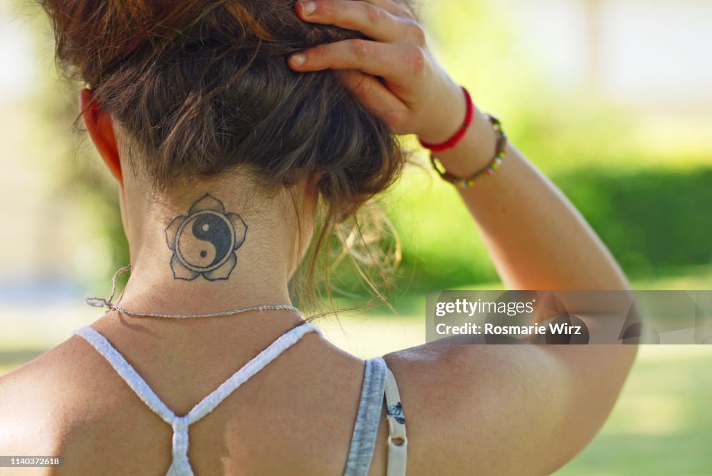 Young woman back view showing tatoo