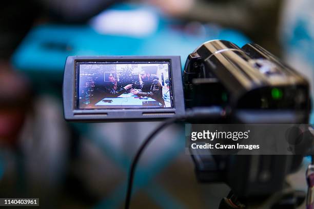 video camera is recording a man and a woman during an interview - reporterstil stock-fotos und bilder