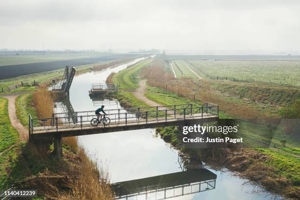 Cyclist crossing bridge over river