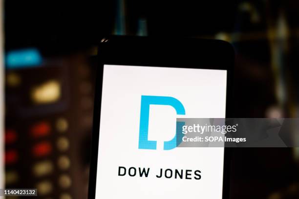 In this photo illustration a logo of the United States international financial publisher Dow Jones & Company seen displayed on a smartphone.