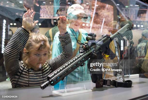 Young girl seen admiring a weapon by Sig Saur that will be featured in the upcoming John Wick film during an exhibition. NRA members and leaders...