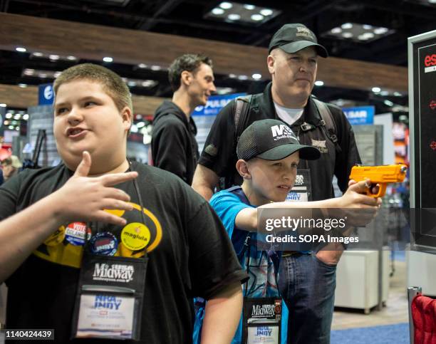 Members are seen checking out weapons and accessories during an exhibition. NRA members and leaders gather in Indianapolis, Indiana for the annual...