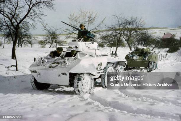 Camouflaged Light Armored Car M8 and one that was not Painted White, Ardennes-Alsace Campaign, Battle of the Bulge, 1945.