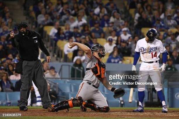 Enrique Hernandez of the Los Angeles Dodgers reacts to a strike call by MLB umpire Dan Bellino as catcher Erik Kratz of the San Francisco Giants...