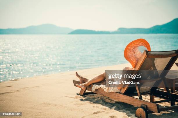 vrouw in strandstoel - ligstoel stockfoto's en -beelden