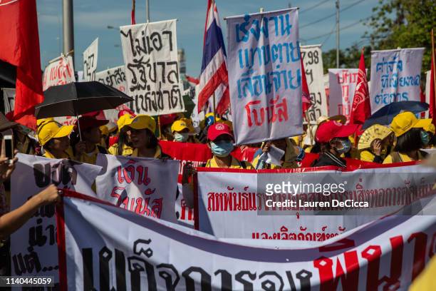 Thai union members march with picket signs calling for increased wages during a Labor Day parade on May 1, 2019 in Bangkok, Thailand. The Thai...