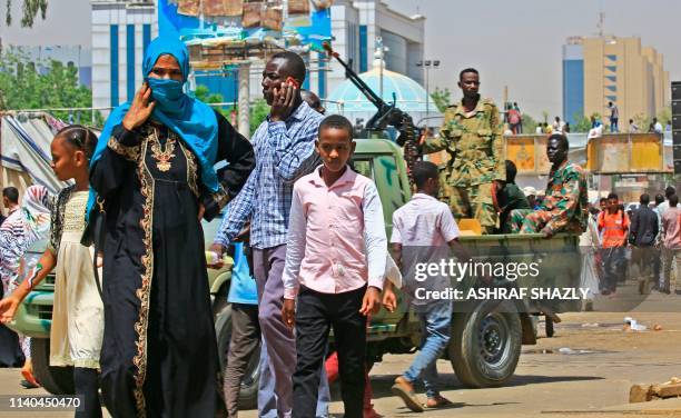 Sudanese soldiers stand guard on an armoured military vehicle as protesters continue their sit-in outside the army headquarters in the capital...