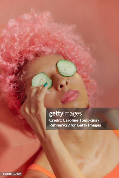 portrait of young confident women with cucumbers on eyes - cucumber imagens e fotografias de stock