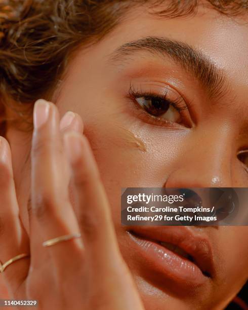 closeup of a young confident woman applying foundation - beauty haut stock-fotos und bilder