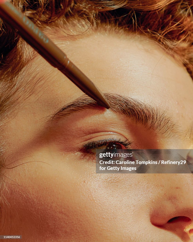Closeup of a Young Confident Woman Filling in her Eyebrows