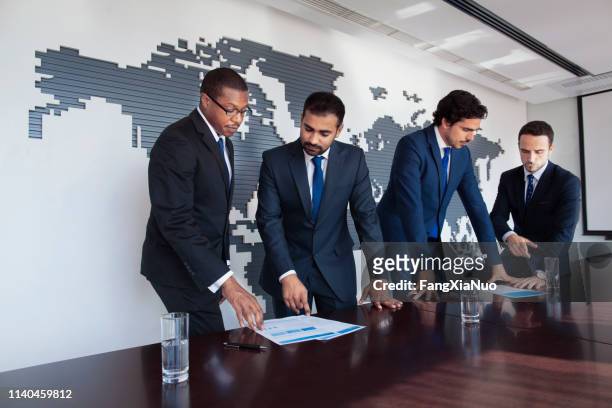 businessmen at conference table viewing documents - 2015 world series imagens e fotografias de stock