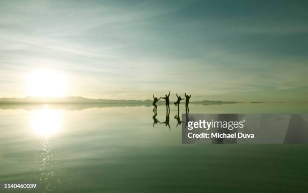 people with arms up on magical background - salar de uyuni stock pictures, royalty-free photos & images