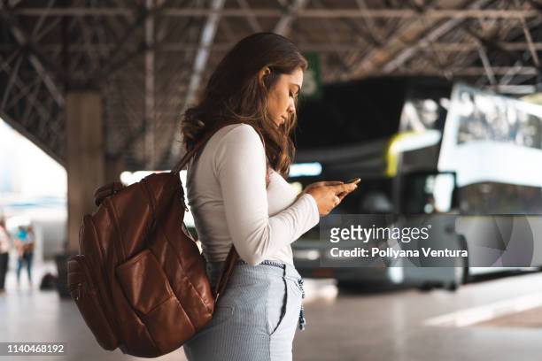 woman waiting for bus at the bus station - bus station stock pictures, royalty-free photos & images