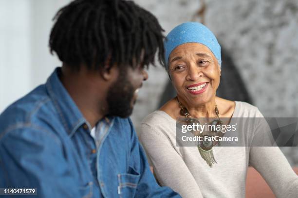 senior mother with cancer spending time with her adult son - coping stock pictures, royalty-free photos & images