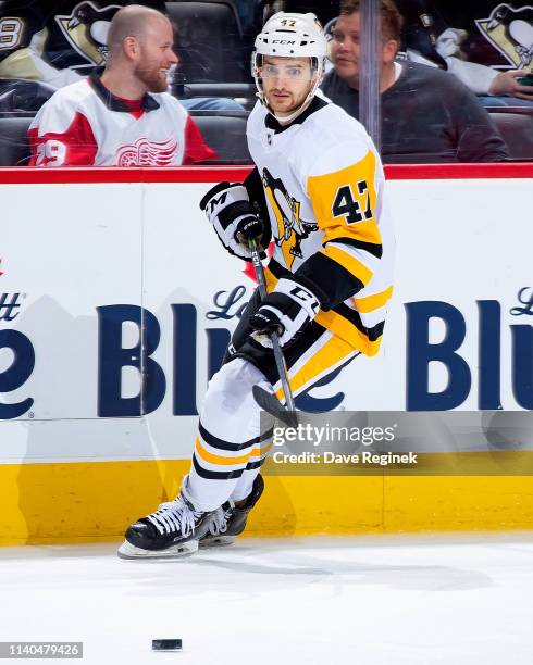 Adam Johnson of the Pittsburgh Penguins passes the puck against the Detroit Red Wings during an NHL game at Little Caesars Arena on April 2, 2019 in...