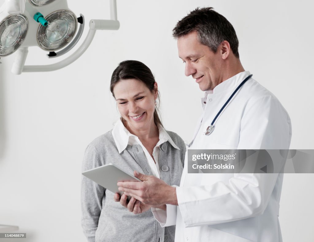 Doctor looking at tablet computer with patient