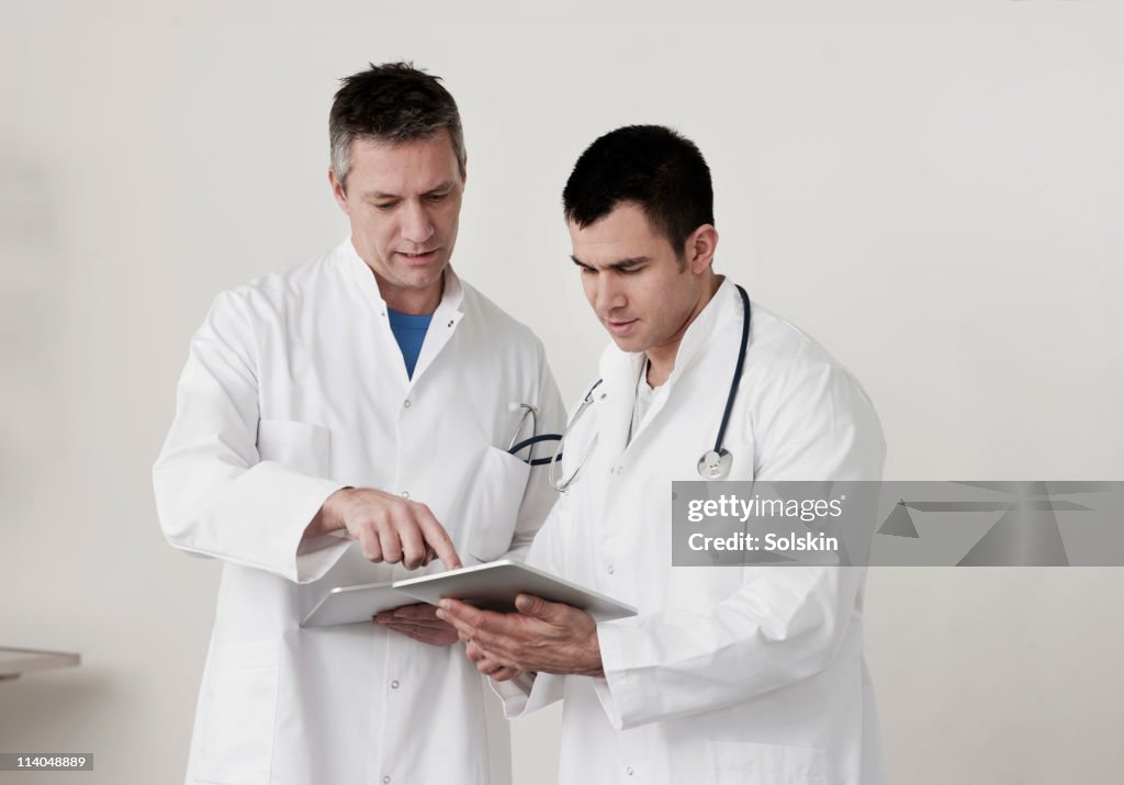 Doctors looking at tablet computers