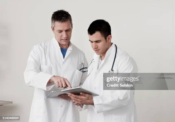 doctors looking at tablet computers - hørsholm stock pictures, royalty-free photos & images