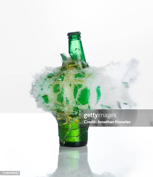 a beer bottle exploding on  a white background - alcohol abuse stock pictures, royalty-free photos & images