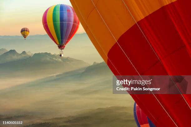 colorful hot-air balloons flying over the doi luang chiang dao with sunrise and morning mist at chiang mai - hot air ballon foto e immagini stock