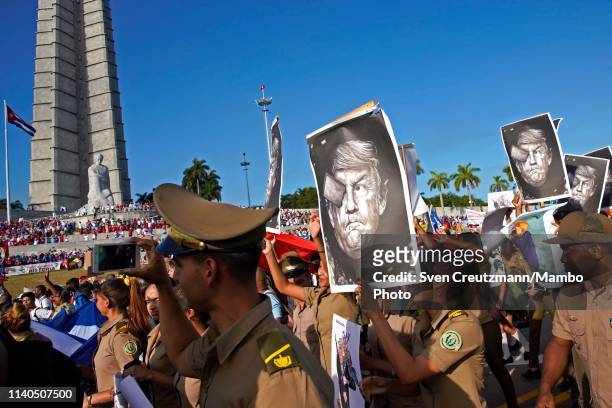 Cuban military personnel carry caricatures of US President Donald Trump as they pass in front of the Jose Marti monument during the May Day parade,...
